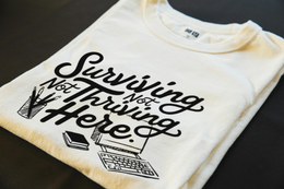 Folded T-Shirt mockup - Surviving Not Thriving Here (CG2072) [dynamic_lifestyle] | v=1775151954754