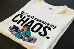 Folded T-Shirt mockup - KPIs can't measure my chaos. (CG3926) [dynamic_lifestyle]